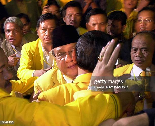 Golkar party leader, Akbar Tanjung hugs former Indonesian military chief Wiranto after he won the Golkar party's nomination for the presidency at a...