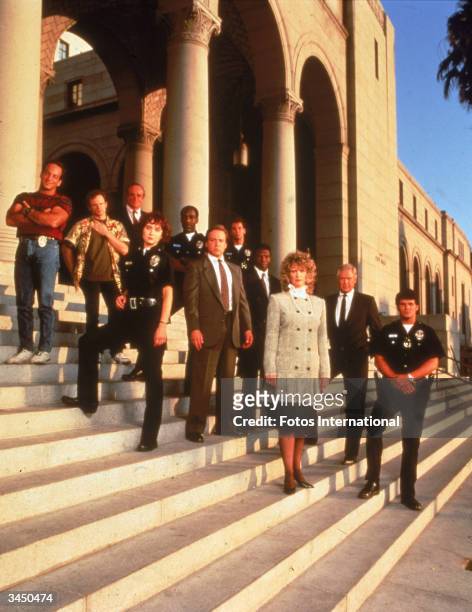Promotional portrait of the cast of the television series, 'Cop Rock' posing on the steps of a City Hall, 1990.