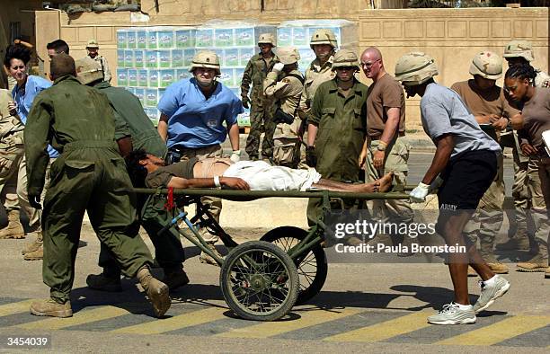 Army medical personnel evacuate an Iraqi prisoner from Abu Ghraib prison April 20, 2004 in Baghdad. Insurgents fired 12 mortars on the Baghdad...