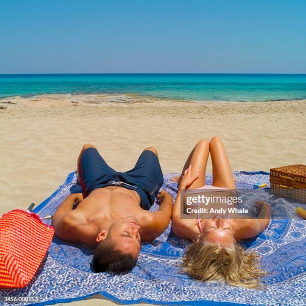 Couple Sunbathing On Beach High-Res Stock Photo Getty Images