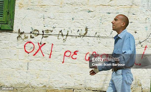 Man walks past a wall with 'OXI' or 'NO' graffiti on it supporting rejection of a U.N. Reunification peace plan, on April 22, 2004 in Limassol,...