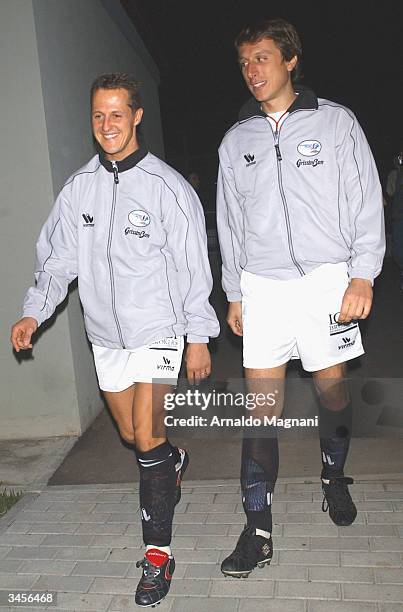 Ferrari Formula One driver Michael Schumacher of Germany and the son of Ferrari chief Luca Cordero di Montezemolo walk through the tunnel before a...