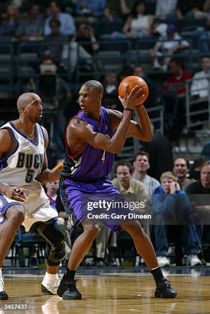 Chris Bosh of the Toronto Raptors is defended by Brian Skinner of the Milwaukee Bucks during the game at Bradley Center on April 14, 2004 in...