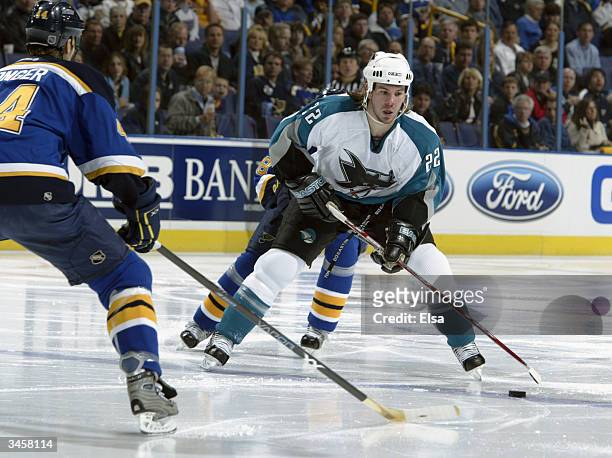 Scott Hannan of the San Jose Sharks plays the puck at the blueline against Chris Pronger of the St. Louis Blues in game three of the Western...
