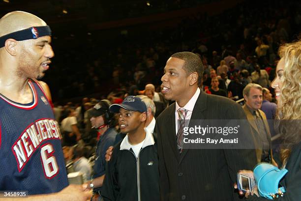 Kenyon Martin of the New Jersey Nets greets Rapper Jay-Z during Game three of the Eastern Conference Quarterfinals of the 2004 NBA Playoffs between...