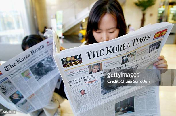 South Koreans read newspaper reports on North Korea's train explosion on April 23, 2004 in Seoul, South Korea. Two fuel trains collided and caused a...