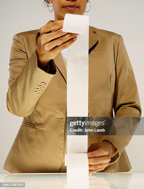woman holding receipt - long receipt stock pictures, royalty-free photos & images