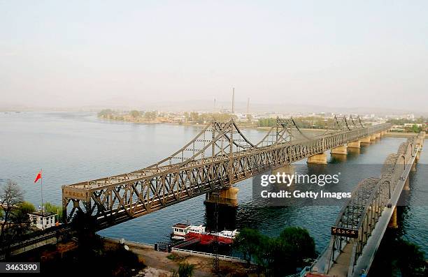 View of the deserted No Name Bridge on the Yalu River, which serves for freight transport at night, beside the Sino Korea Friendship bridge linking...