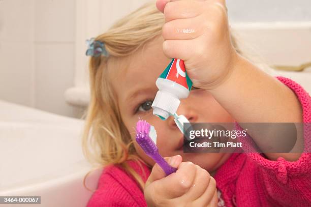 girl squeezing toothpaste - quetschen stock-fotos und bilder