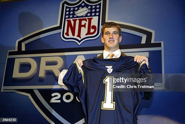 Eli Manning holding up a San Diego Chargers jersey was selected first pick overall by the Chargers then traded to the New York Giants for Philip...