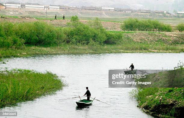 Chinese boatsmen return from a quick encounter with North Korean soldiers at a border crossing about 20 km north of the Ryochon disaster site, April...