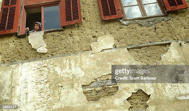 Turkish Cypriot woman peers out from a window a day after the referendum in the Turkish side of the divided city of Nicosia April 25, 2004 in...