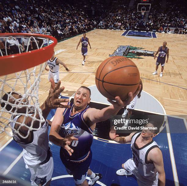 Greg Ostertag of the Utah Jazz lays the ball up over Michael Olowokandi of the Minnesota Timberwolves during the game at the Target Center on April...