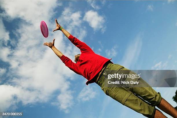 man catching frisbee - frisbee fotografías e imágenes de stock