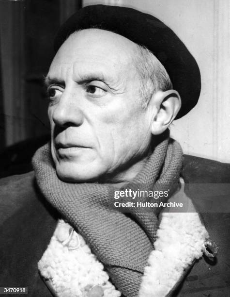 Portrait of Spanish-born artist Pablo Picasso in a winter coat, scarf, and beret, 1950s.