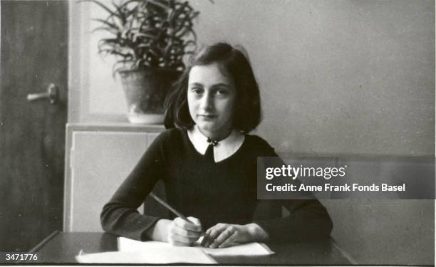 German diarist Anne Frank writes at her desk prior to her and her family going into hiding during World War II, Amsterdam, Netherlands, early 1940s.