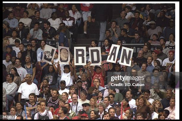 Fans of Chicago Bulls guard Michael Jordan cheer and wave signs during a game against the Los Angeles Clippers at the Sports Arena in Los Angeles,...