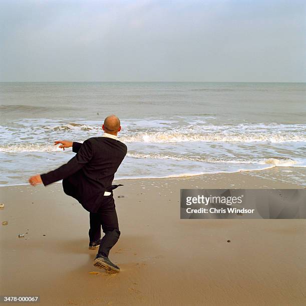 man throwing stones into sea - skimming stones stock pictures, royalty-free photos & images