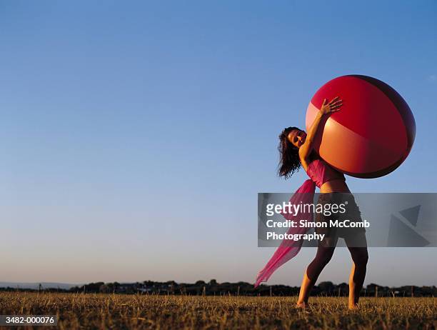 woman holding large beach ball - big hug stock pictures, royalty-free photos & images