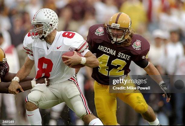 Quarterback Stanley Jackson of the Ohio State Buckeyes moves the ball as Arizona State Sun Devils linebacker Pat Tillman chases him during the Rose...