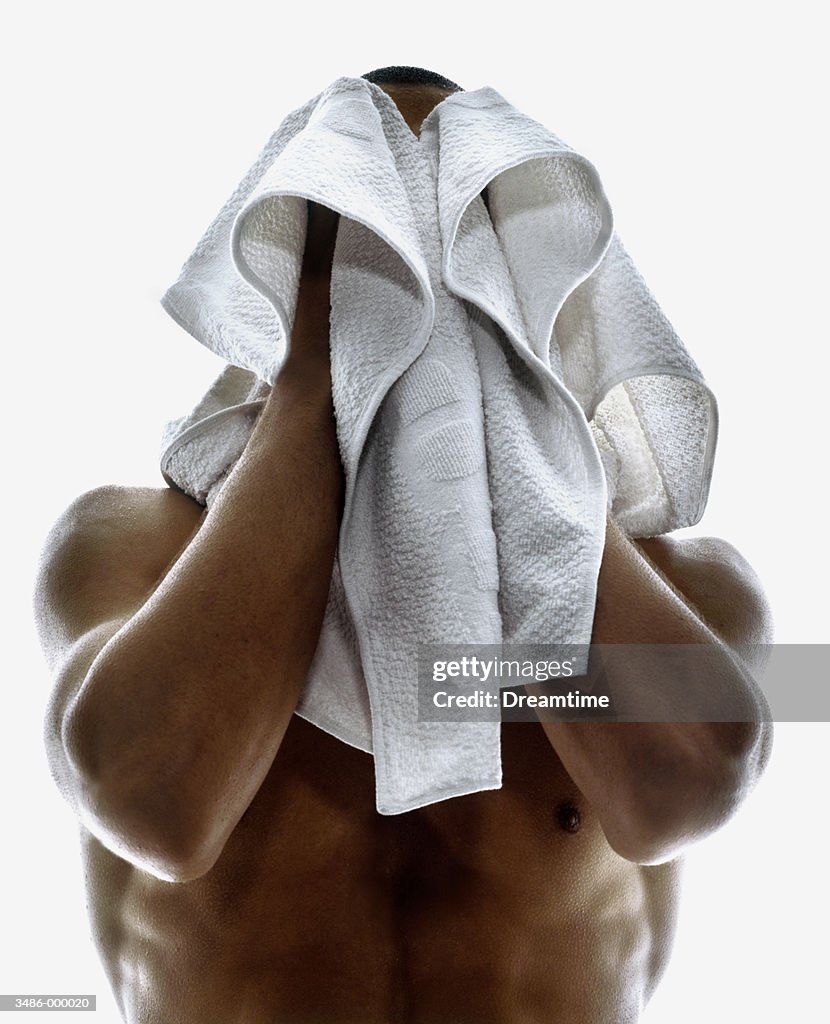 Man Covering Face with Towel