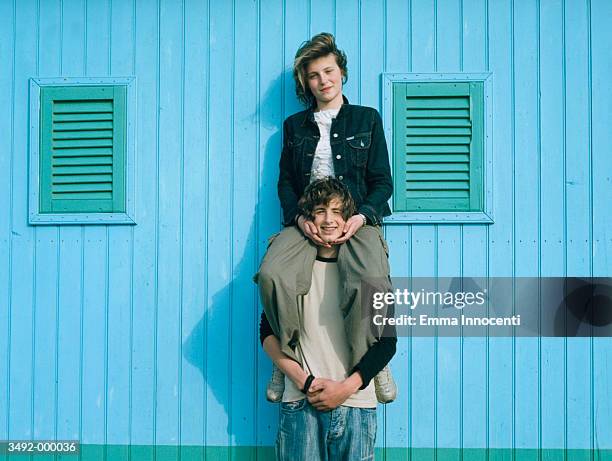 girl sits on boy's shoulders - shoulder rides stock pictures, royalty-free photos & images