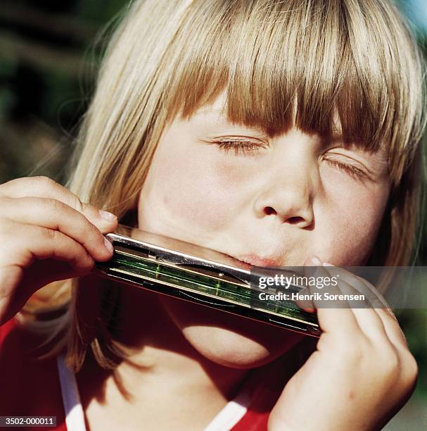 girl playing a harmonica - harmonica stock pictures, royalty-free photos & images