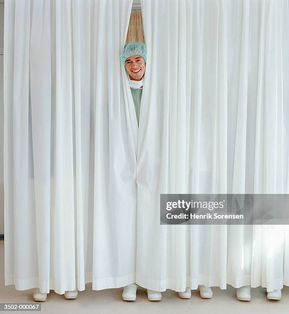 surgeon behind curtains - funny surgical masks stockfoto's en -beelden