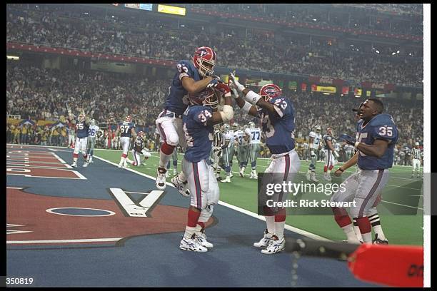 Running back Thurman Thomas of the Buffalo Bills celebrates with his teammates after scoring a touchdown during Super Bowl XXVIII against the Dallas...