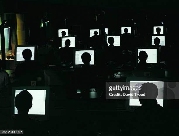 people working on pc's in dark - bustling office stock pictures, royalty-free photos & images