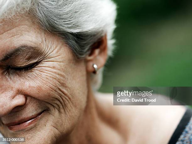 elderly woman smiling - woman portrait eyes closed stock-fotos und bilder