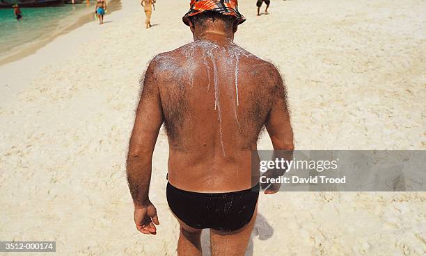 hairy backed man on beach - hairy back stock pictures, royalty-free photos & images