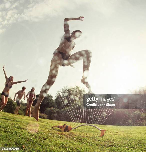 friends having fun - jumping sprinkler stock pictures, royalty-free photos & images