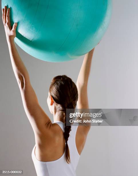 woman holding pilates ball - pilates ball man stock-fotos und bilder