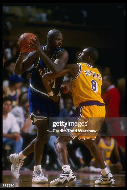 Forward George McCloud of the Dallas Mavericks moves the ball as Los Angeles Lakers guard Kobe Bryant covers him during a game at Selland Arena in...