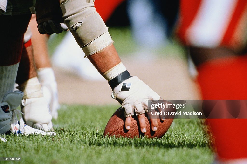 Professional American football, player holding ball on turf