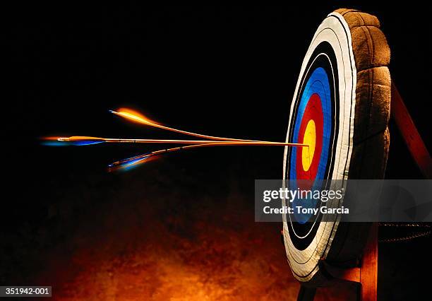 arrow splitting another arrow in bull's-eye of target - arrows target stock pictures, royalty-free photos & images