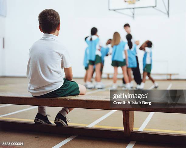 boy excluded from team - child alone stockfoto's en -beelden