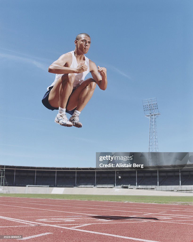 Athlete Jumping on Track
