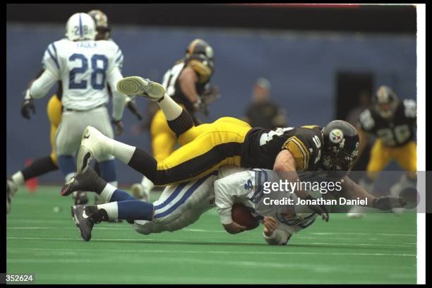 Linebacker Chad Brown of the Pittsburgh Steelers tackles Indianapolis Colts quarterback Jim Harbaugh during a playoff game at Three Rivers Stadium in...