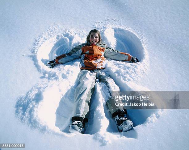 girl lying in snow - après ski stock-fotos und bilder