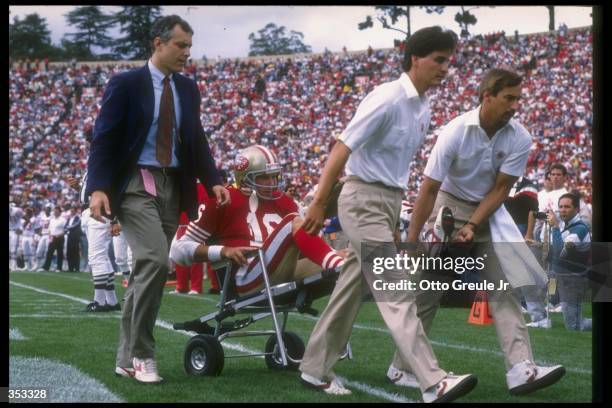 Quarterback Joe Montana of the San Francisco 49ers is taken off the field after being injured during a game against the New England Patriots at...