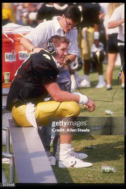 Quarterback Brett Favre of the Southern Mississippi Golden Eagles talks to coaches in the press box while sitting on the bench during the Golden...