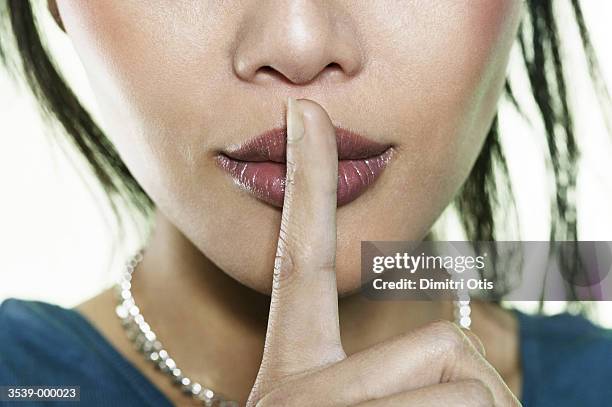 woman holding finger to lips - finger on lips bildbanksfoton och bilder