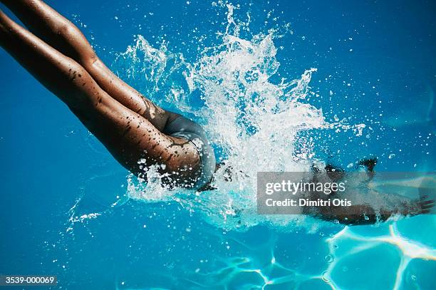 woman diving into water - woman diving underwater stock-fotos und bilder