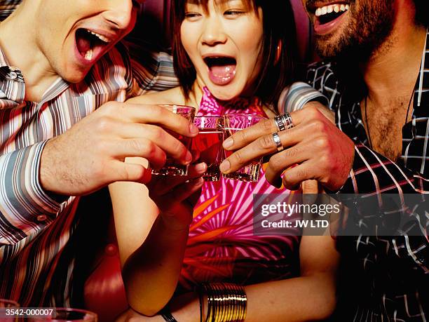 friends drinking in nightclub - shot glass stock pictures, royalty-free photos & images