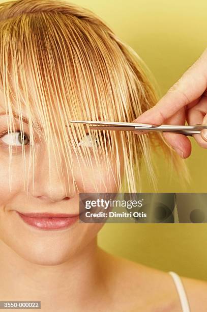 woman having hair cut - cut on finger 個照片及圖片檔