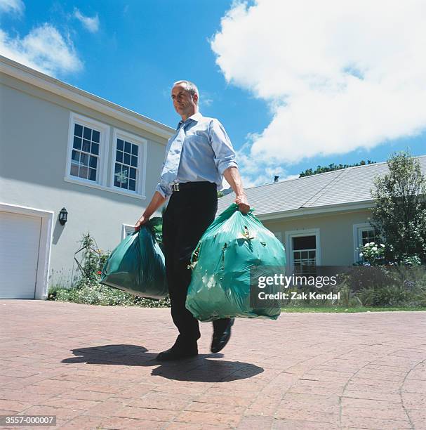 man carrying garbage bags - garbage man stockfoto's en -beelden