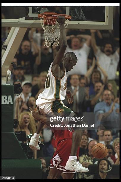Forward Shawn Kemp of the Seattle SuperSonics dunks over Chicago Bulls forward Dennis Rodman during a game at the Key Arena in Seattle, Washington....