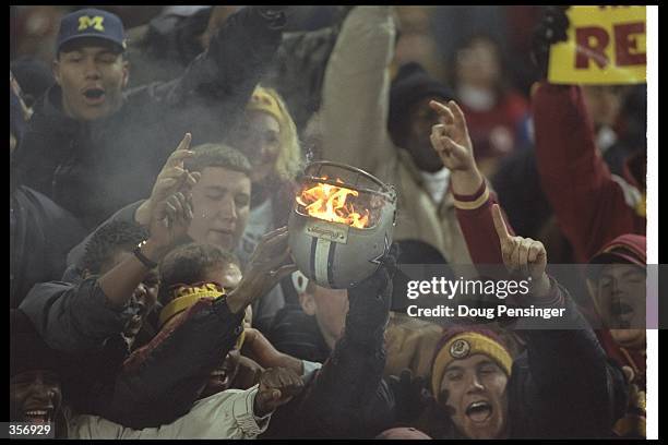 Washington Redskins fans set fire to a Dallas Cowboys helmet during a game at RFK Stadium in Washington, D. C. The Redskins won the game, 37-7....